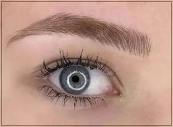 Close-up of eyebrow microblading, featuring precise hair-like strokes for naturally fuller brows.